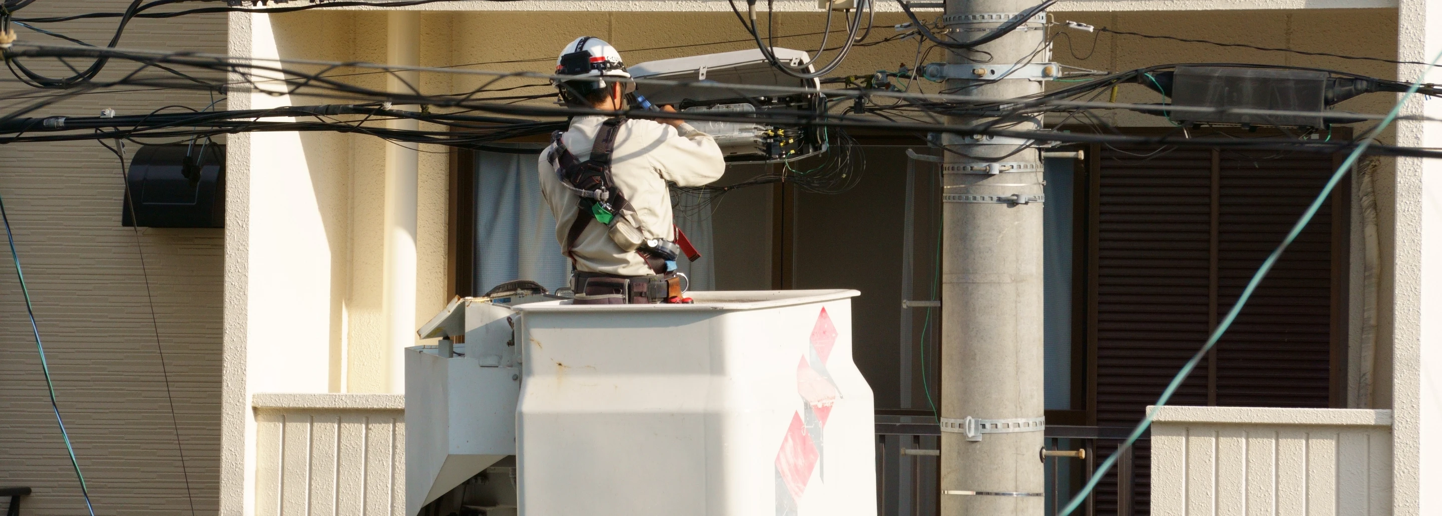 高所作業車で電気設備を点検する作業員
